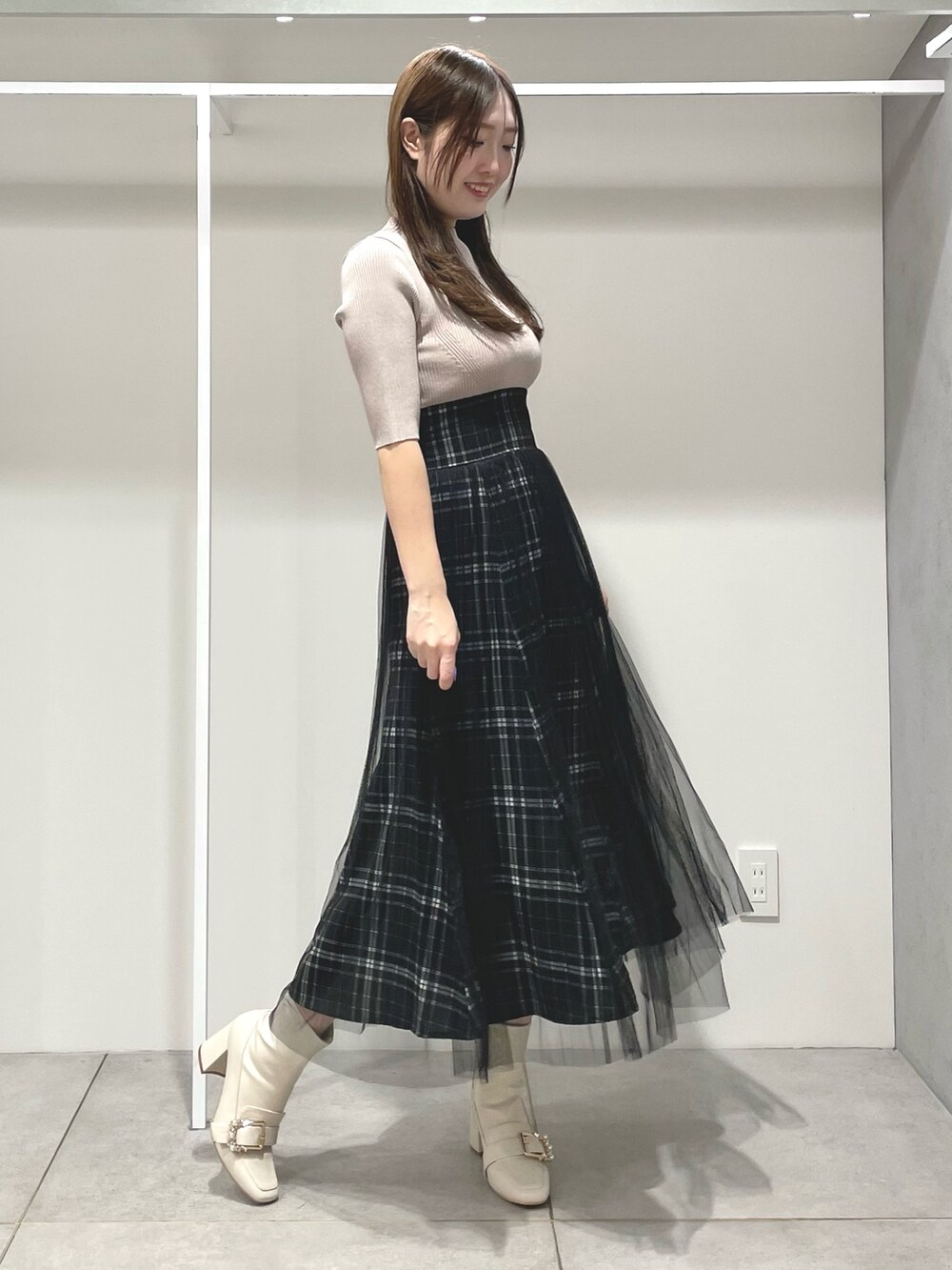 ベージュ系のワンピース、ピンク系のトレンチコート、ホワイト系のブーツを着用したレディースの春コーディネートの7枚目の写真