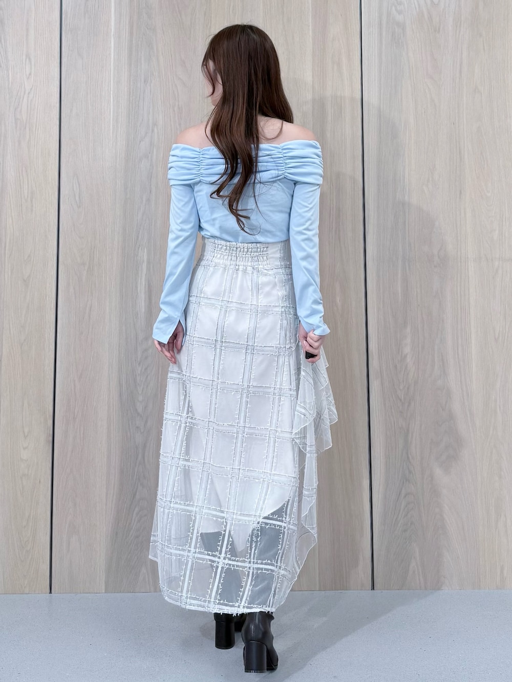 ブルー系のTシャツ/カットソー、ホワイト系のスカート、ブラウン系のブーツを着用したレディースの冬コーディネートの3枚目の写真