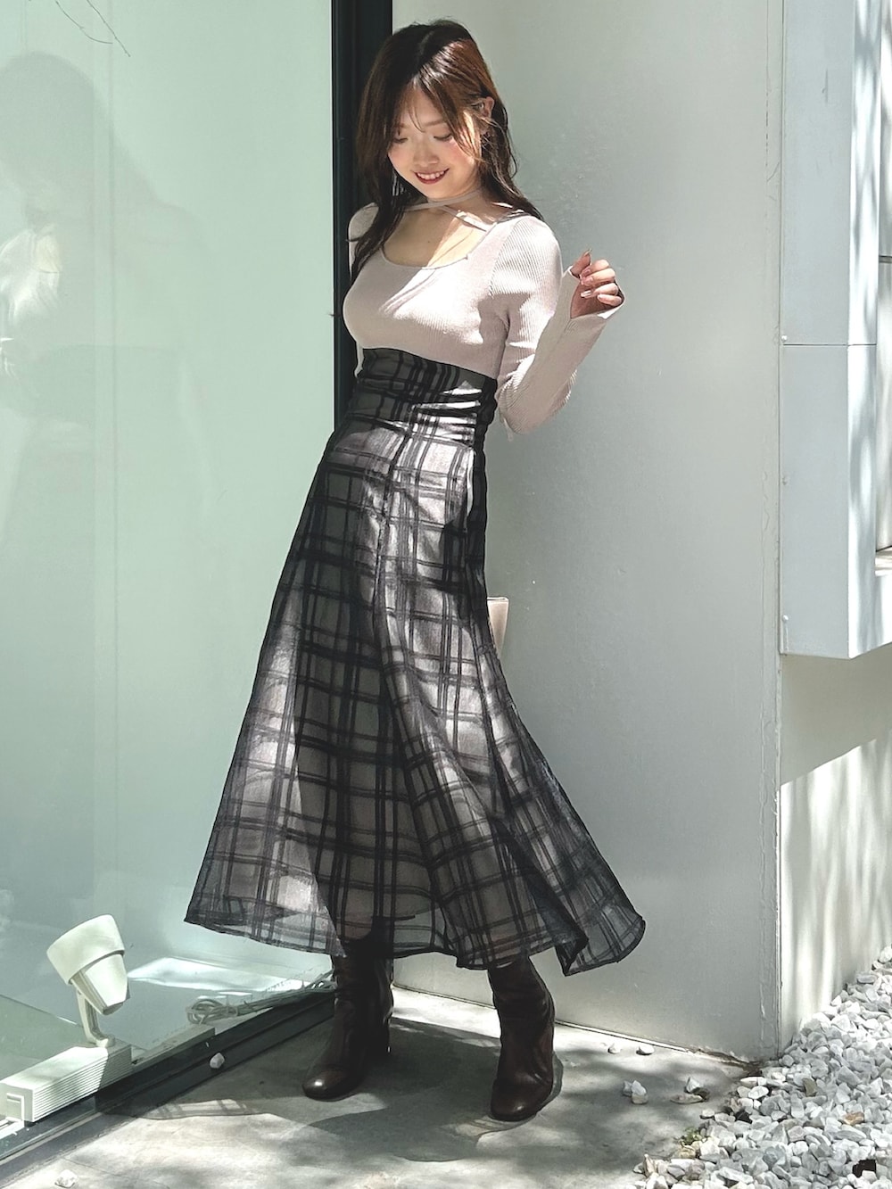 ピンク系のワンピース、ベージュ系のハンドバッグ、ホワイト系のライダースジャケットを着用したレディースの秋コーディネートの7枚目の写真