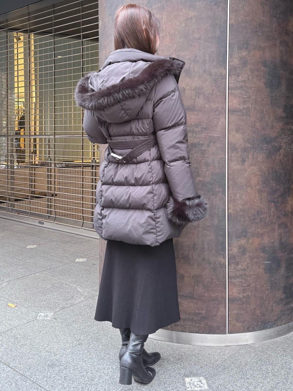 ブラック系のダウンジャケット/コート、ブラック系のブーツ、ブラック系のワンピースを着用したレディースの冬コーディネートの4枚目の写真