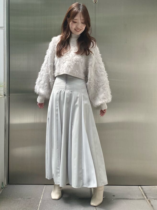 ホワイト系のニット/セーター、グリーン系のスカート、グリーン系のスカートを着用したレディースの秋コーディネートの4枚目の写真