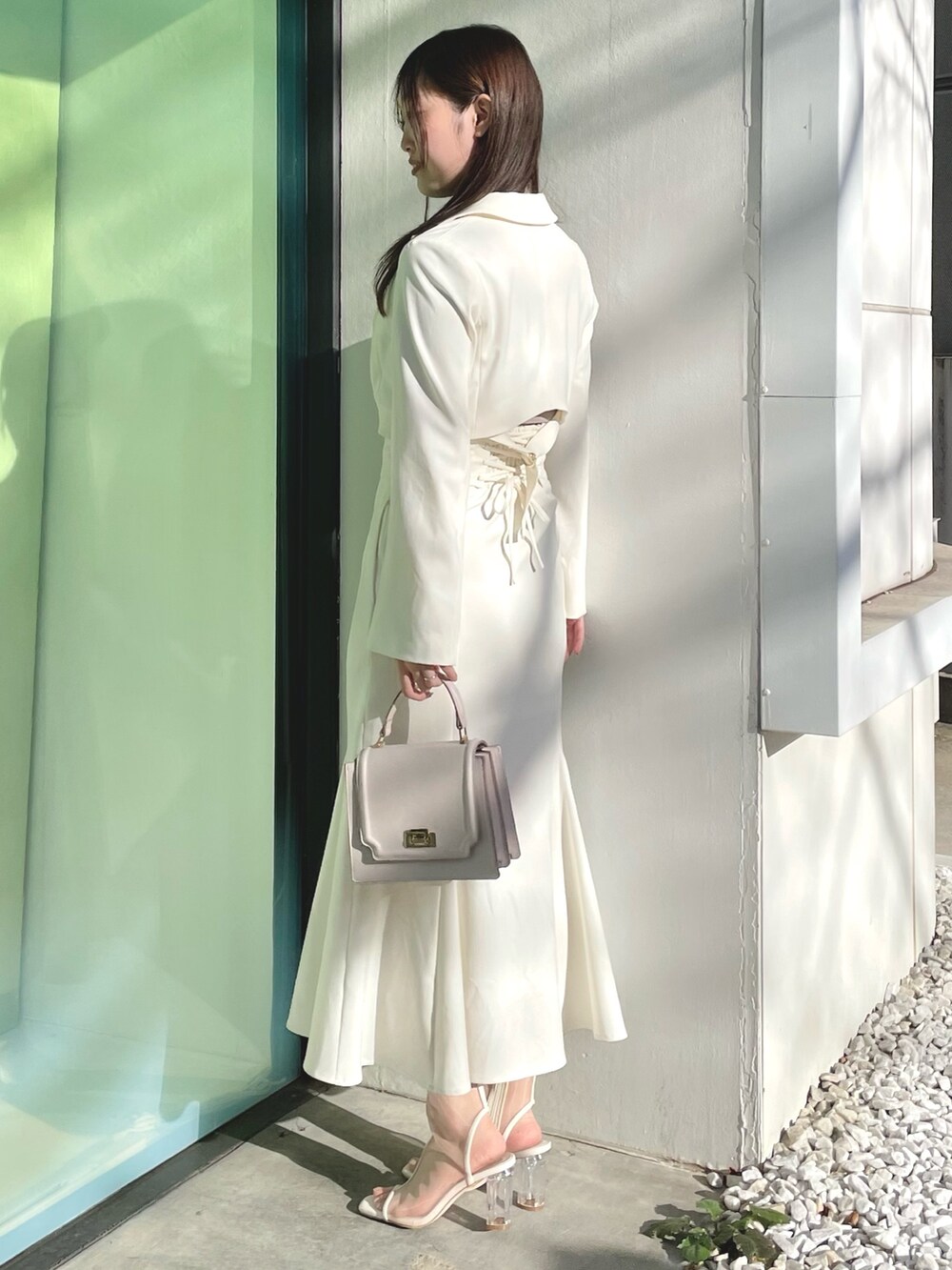 ピンク系のニット/セーター、ホワイト系のテーラードジャケット、ホワイト系のスカートを着用したレディースの春コーディネートの3枚目の写真