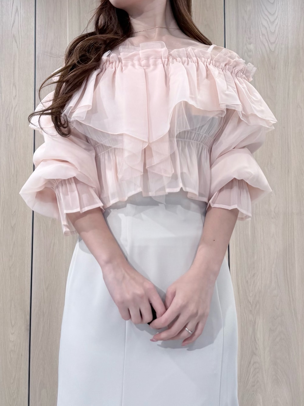 ピンク系のシャツ/ブラウス、ホワイト系のスカート、ホワイト系のパンプスを着用したレディースの春コーディネートの5枚目の写真