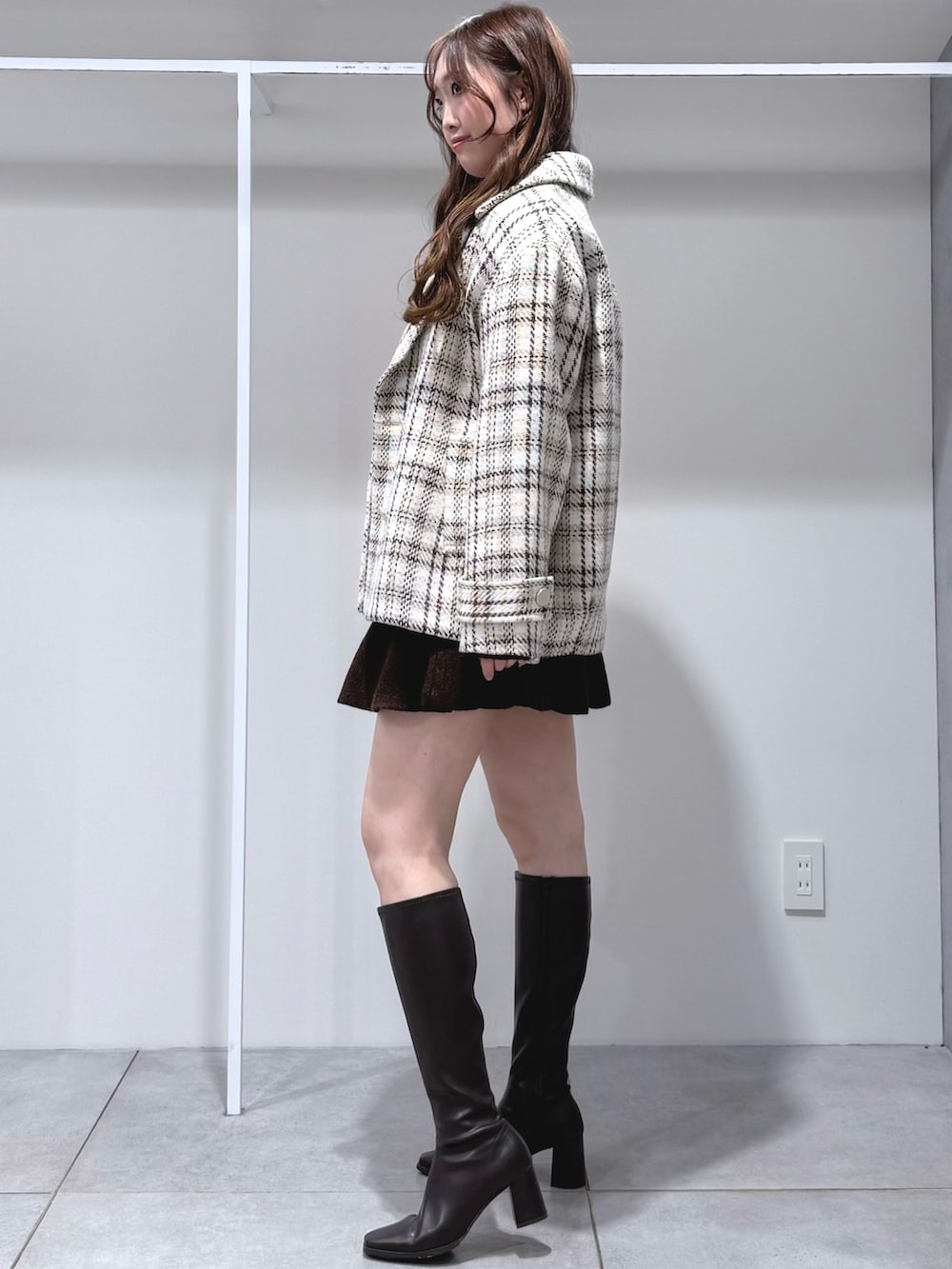 ブラウン系のワンピース、ブラウン系のブーツ、ホワイト系のその他アウターを着用したレディースの秋コーディネートの3枚目の写真