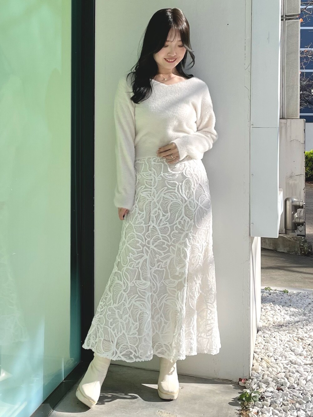 ホワイト系のダウンジャケット/コート、ホワイト系のニット/セーター、ホワイト系のスカートを着用したレディースの冬コーディネートの5枚目の写真