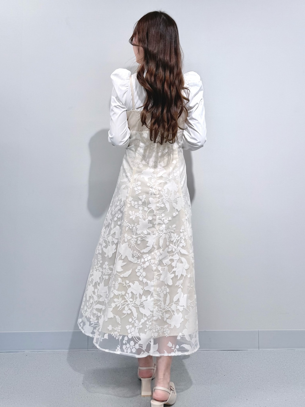 ベージュ系のワンピース、ホワイト系のパンプスを着用したレディースの冬コーディネートの4枚目の写真