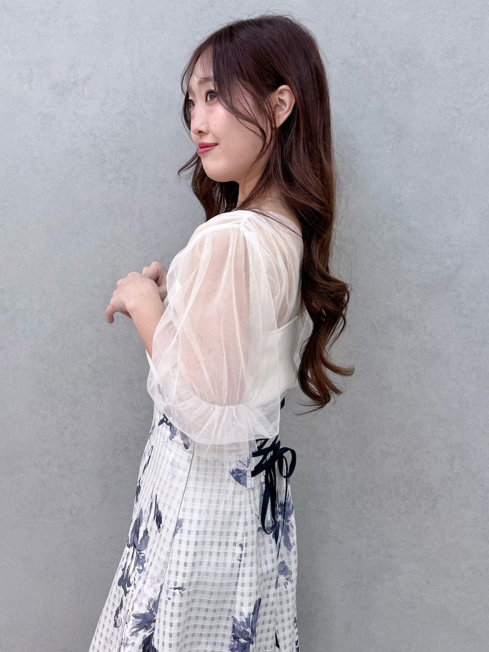 ホワイト系のニット/セーター、シルバー系のサンダル、ブルー系のスカートを着用したレディースの春コーディネートの6枚目の写真