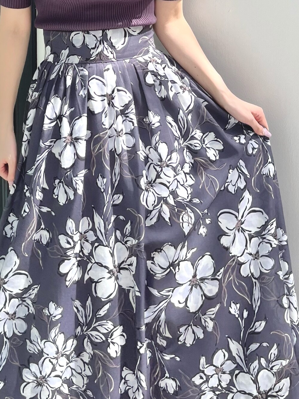 パープル系のスカート、ブラウン系のサンダル、パープル系のニット/セーターを着用したレディースの春コーディネートの8枚目の写真