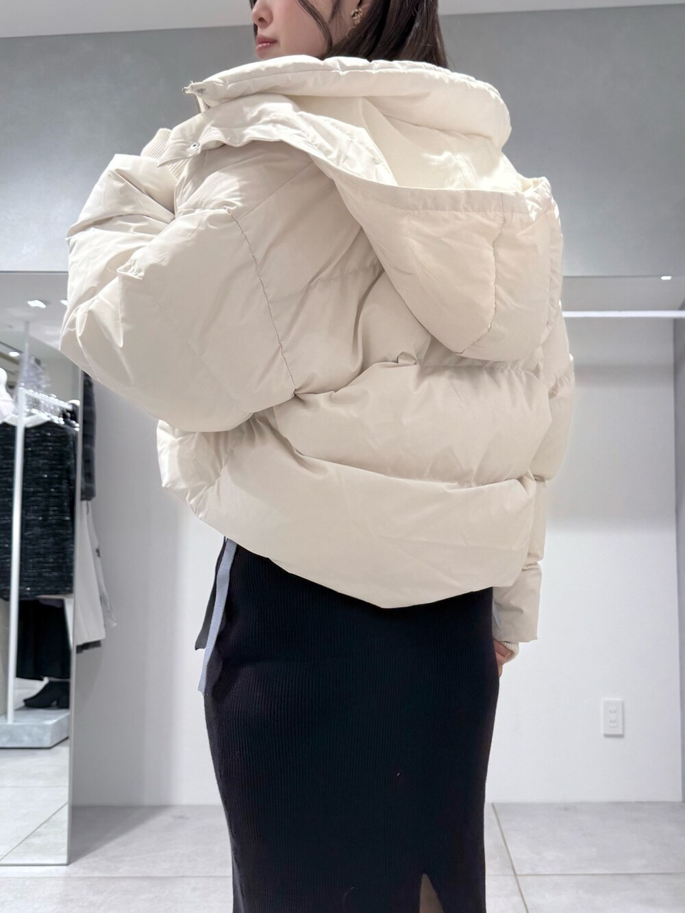 ホワイト系のダウンジャケット/コート、ブルー系のワンピース、ブラック系のブーツを着用したレディースの冬コーディネートの5枚目の写真