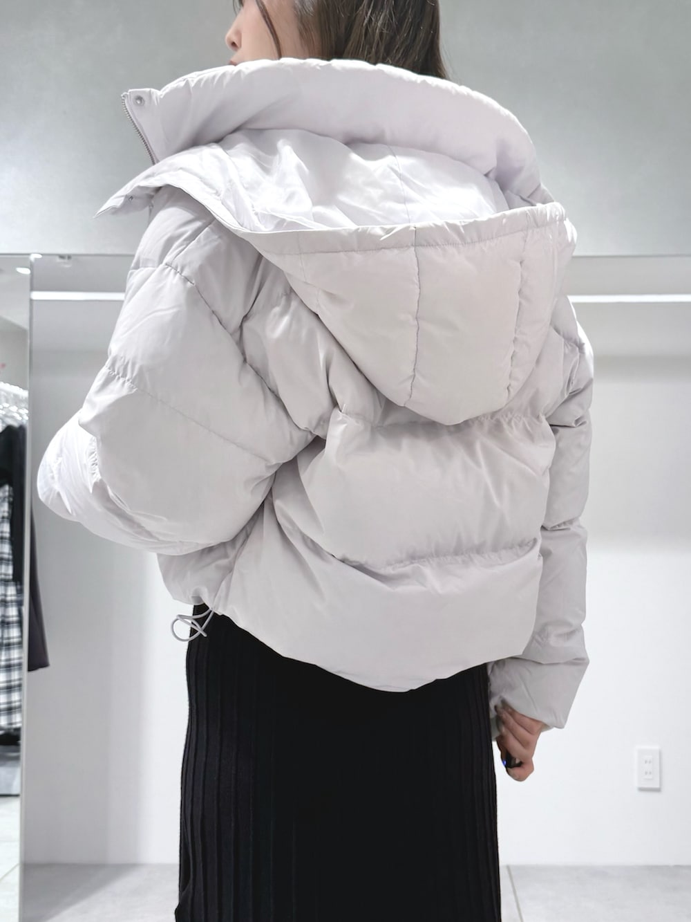 ブラック系のワンピース、ホワイト系のハンドバッグ、ブラック系のブーツを着用したレディースの秋コーディネートの6枚目の写真