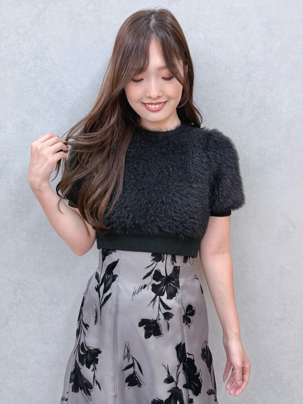 ブラック系のスカート、ブラック系のニット/セーター、ブラック系のブーツを着用したレディースの夏コーディネートの4枚目の写真