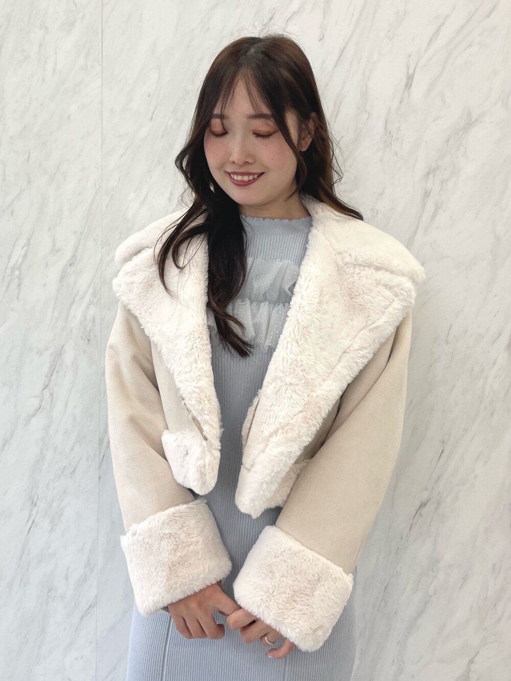 ブルー系のワンピース、ブラック系のブーツ、ベージュ系のムートンコートを着用したレディースの秋コーディネートの4枚目の写真