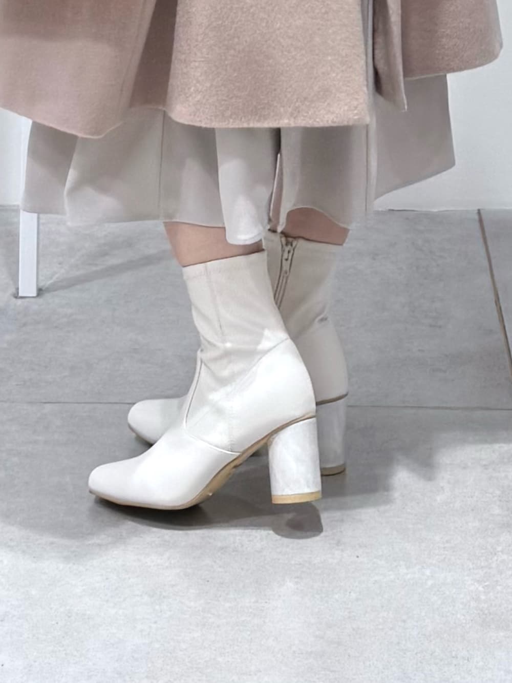 ホワイト系のワンピース、ホワイト系のブーツを着用したレディースの冬コーディネートの7枚目の写真