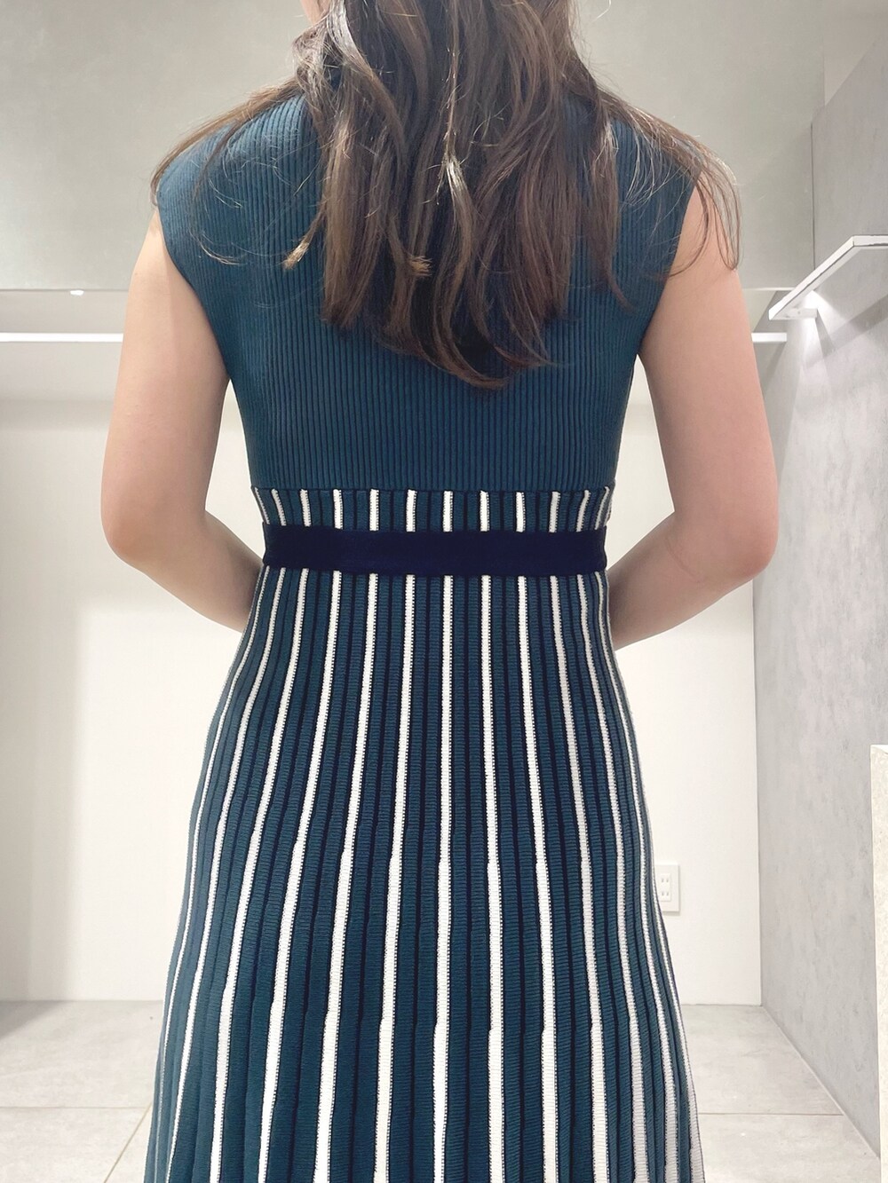 ブラック系のトートバッグ、ブラック系のサンダル、グリーン系のワンピースを着用したレディースの夏コーディネートの7枚目の写真