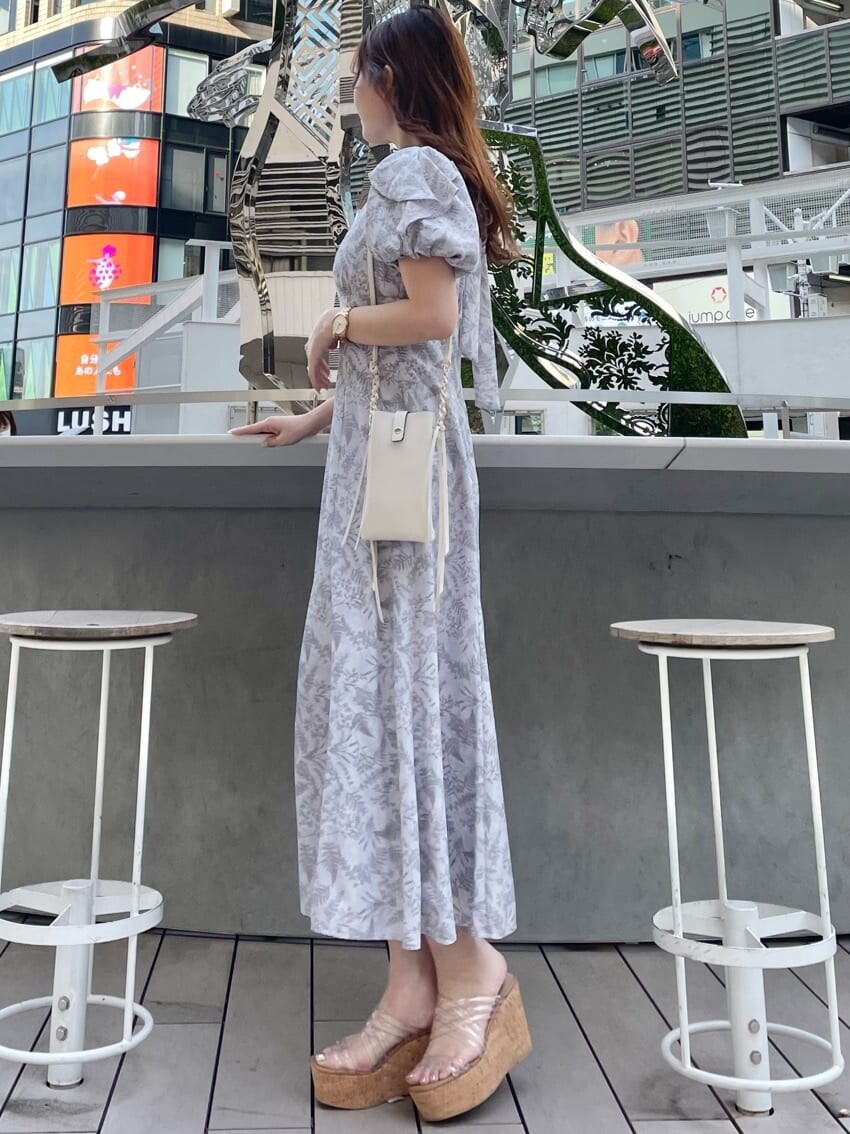 ホワイト系のショルダーバッグ、ピンク系のワンピース、その他のサンダルを着用したレディースの春コーディネートの2枚目の写真