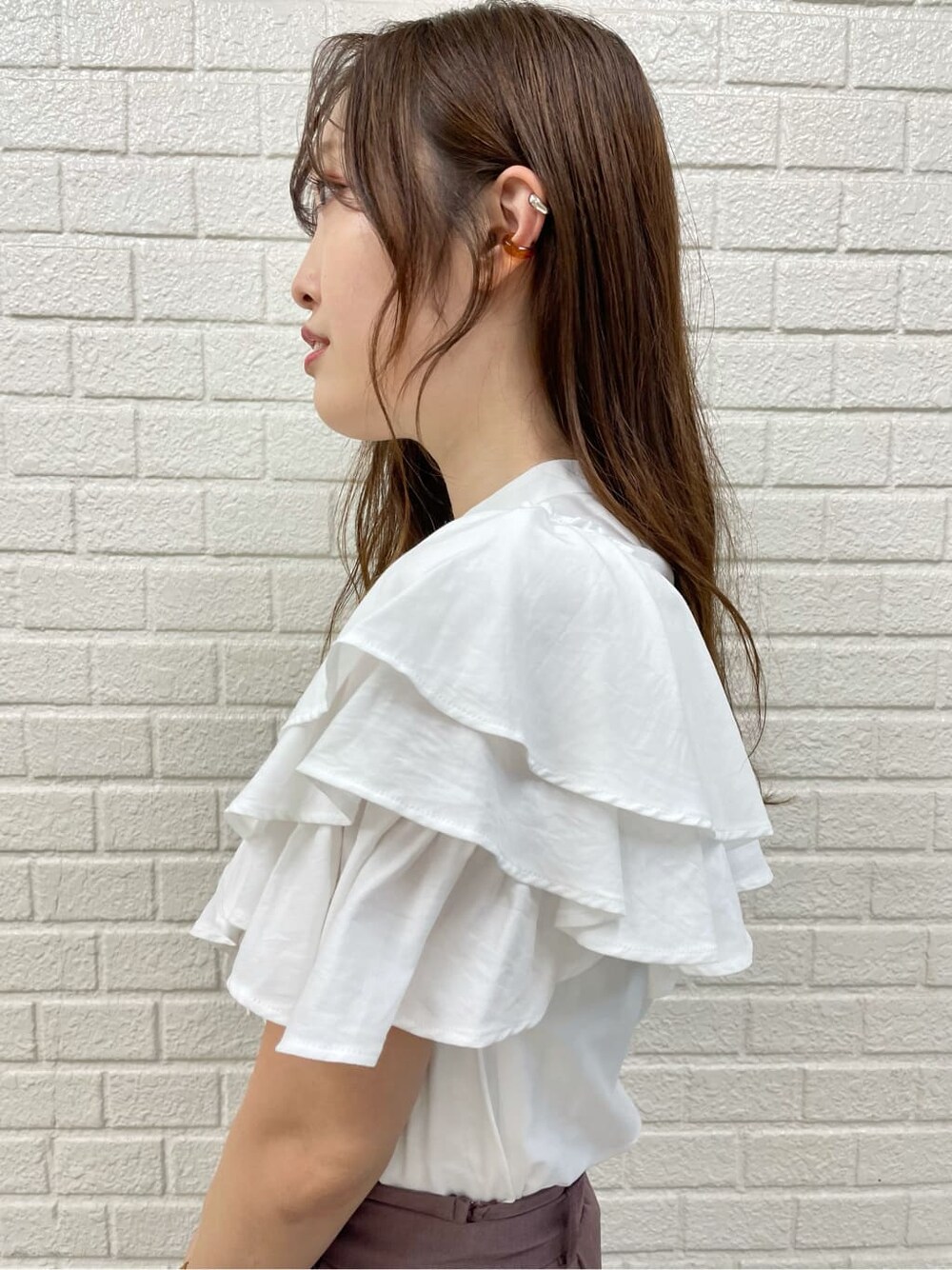 ホワイト系のその他シューズ、ホワイト系のシャツ/ブラウス、ベージュ系のハンドバッグを着用したレディースの秋コーディネートの5枚目の写真