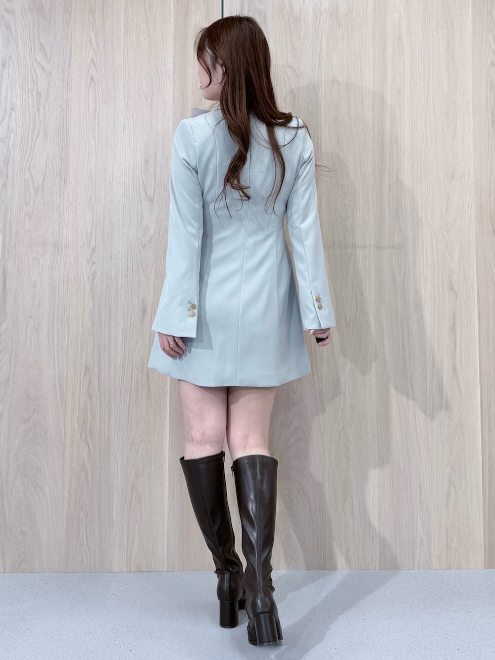 グリーン系のワンピース、ブラウン系のブーツ、グレー系のシャツ/ブラウスを着用したレディースの冬コーディネートの3枚目の写真