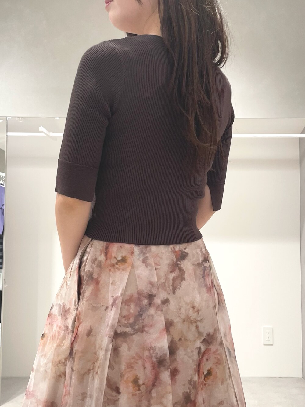 ブラウン系のニット/セーター、ピンク系のスカート、ブラウン系のブーツを着用したレディースの秋コーディネートの6枚目の写真