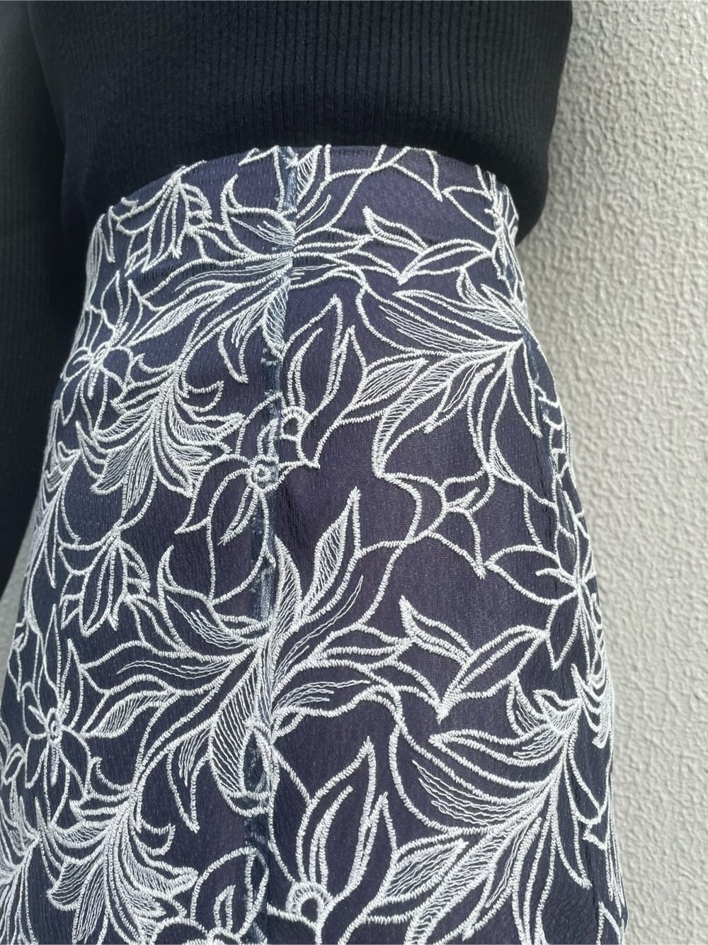 ブラック系のブーツ、ブラック系のニット/セーター、ブルー系のスカートを着用したレディースの冬コーディネートの7枚目の写真