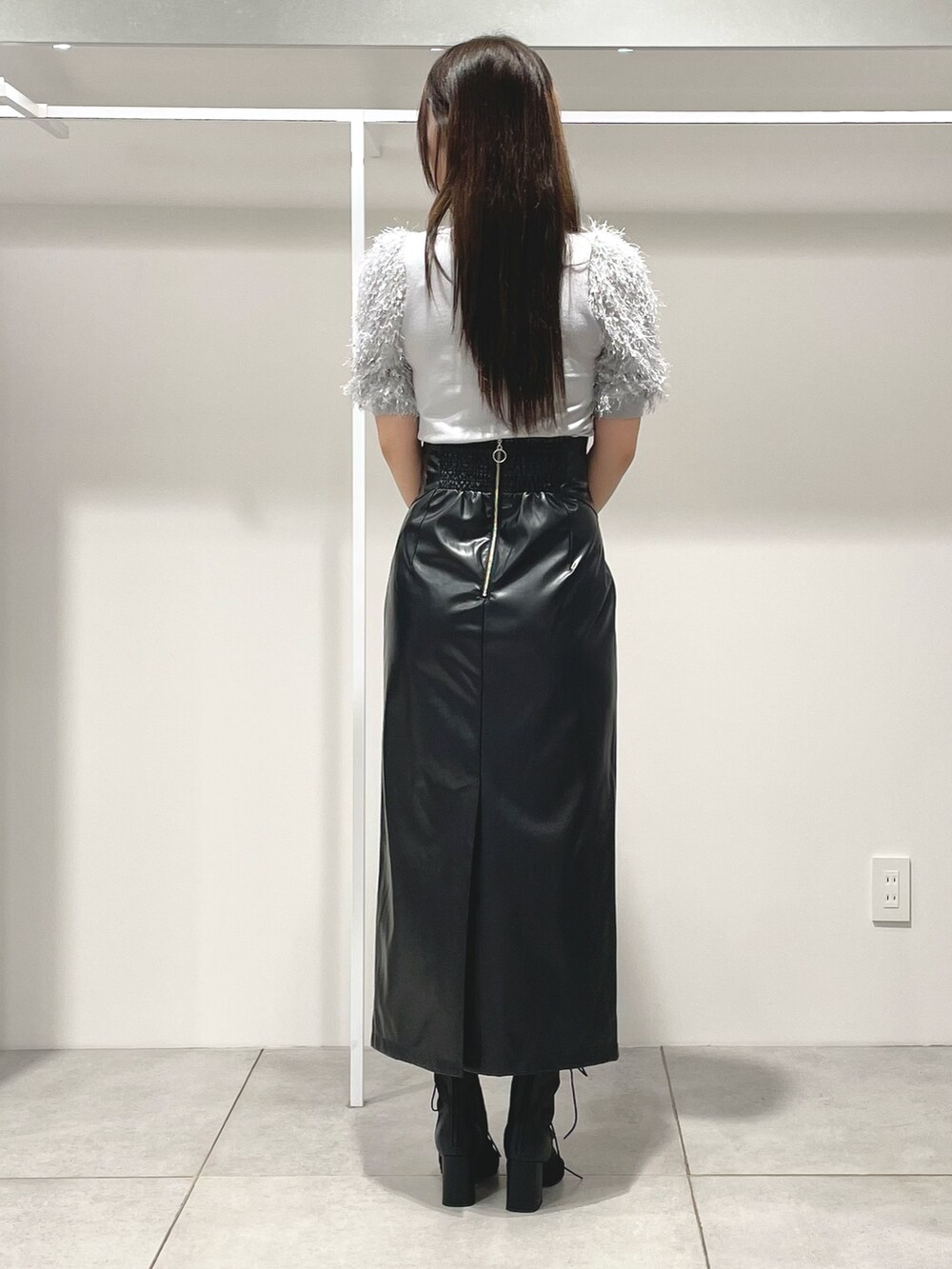 グレー系のニット/セーター、ブラック系のスカート、ブラック系のショルダーバッグを着用したレディースの秋コーディネートの4枚目の写真