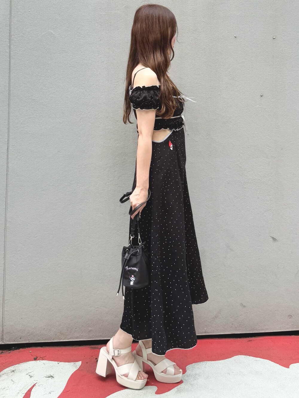 ブラック系のワンピース、ブラック系のショルダーバッグ、ホワイト系のサンダルを着用したレディースの春コーディネートの4枚目の写真