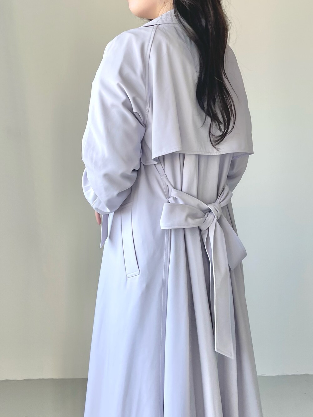 ホワイト系のスカート、パープル系のトレンチコート、ホワイト系のニット/セーターを着用したレディースの冬コーディネートの5枚目の写真