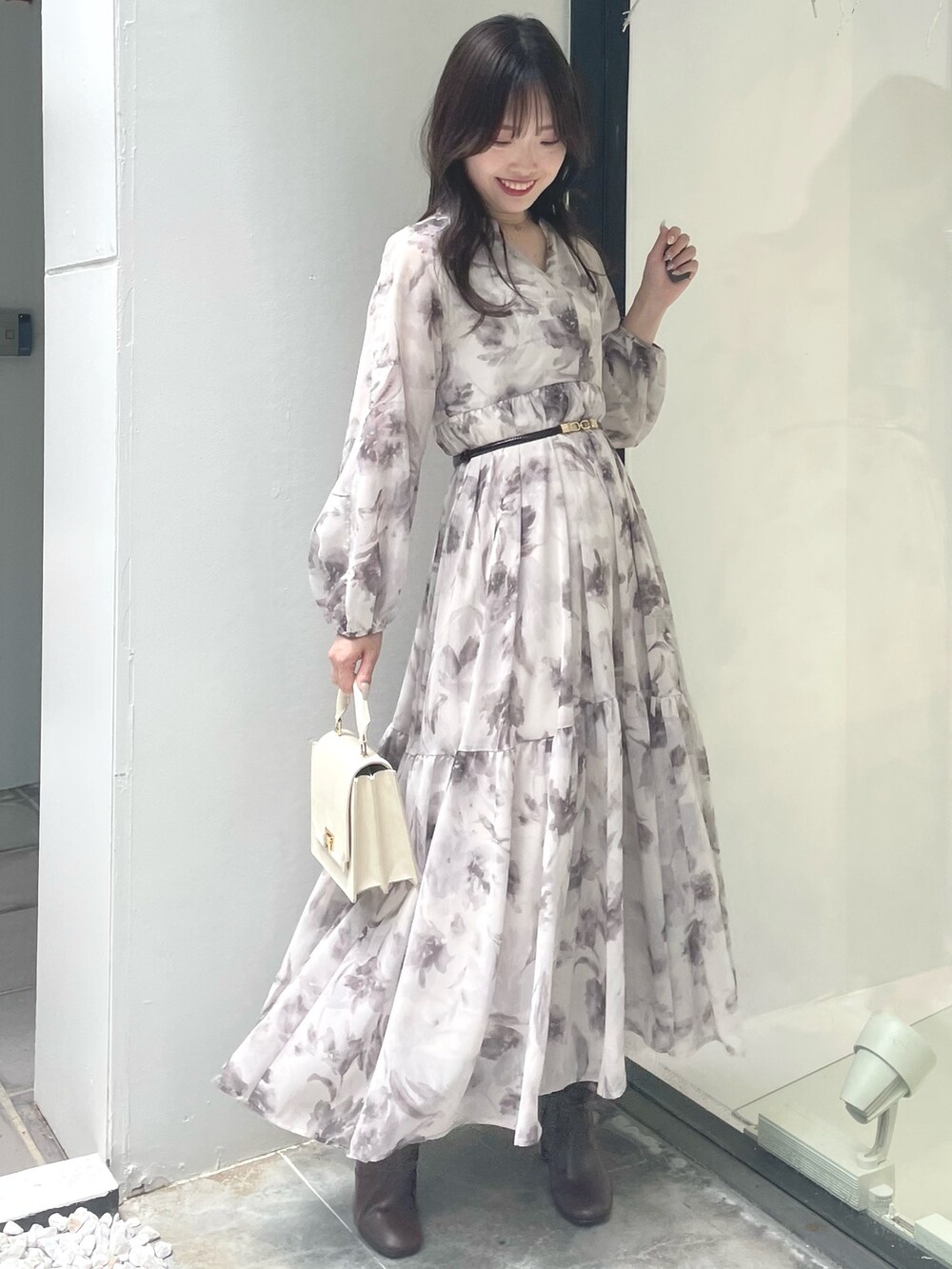 ホワイト系のハンドバッグ、ブラウン系のブーツ、グレー系のその他アウターを着用したレディースの夏コーディネートの7枚目の写真