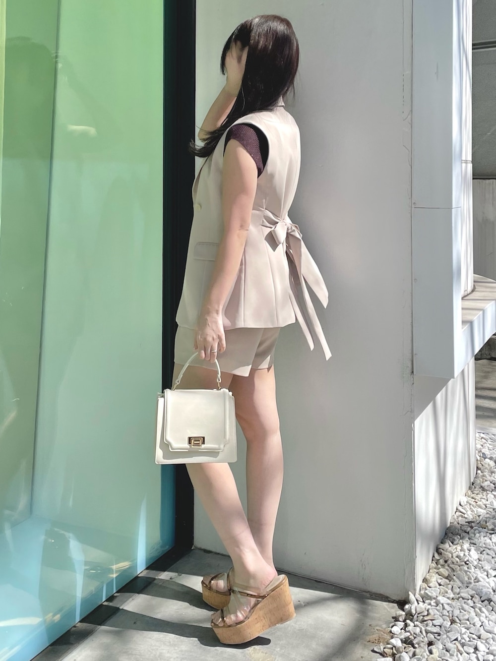 ベージュ系のその他パンツ、ホワイト系のハンドバッグ、ブラウン系のサンダルを着用したレディースの春コーディネートの3枚目の写真