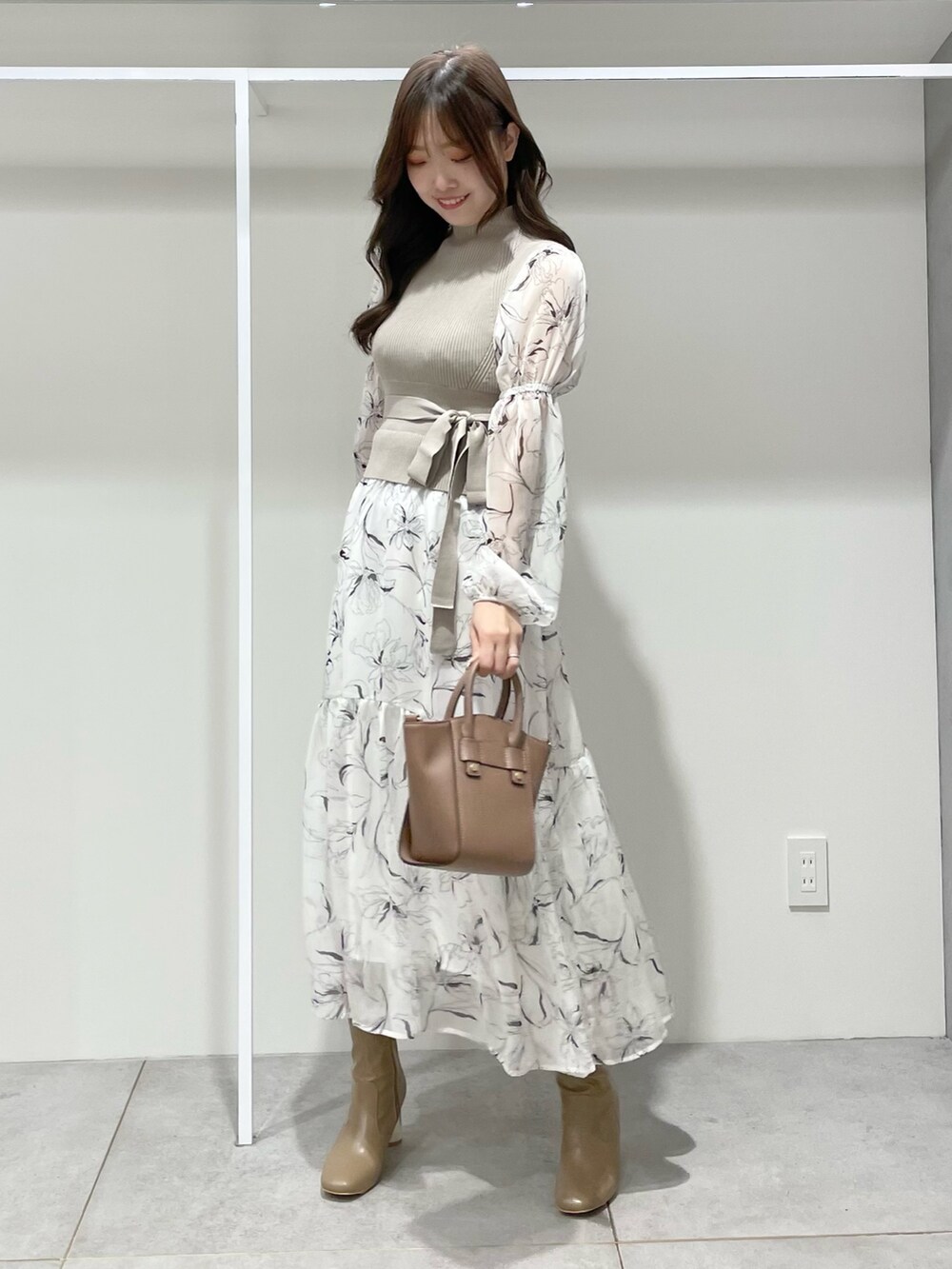 ホワイト系のワンピース、ブラウン系のハンドバッグ、ブラウン系のブーツを着用したレディースの秋コーディネートの4枚目の写真