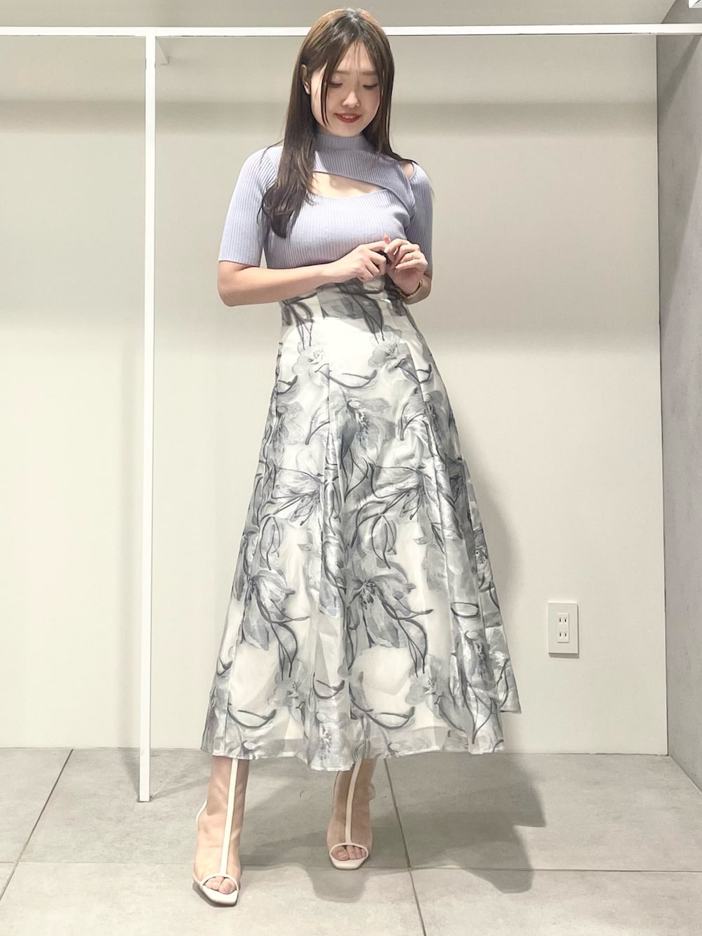 シルバー系のハンドバッグ、ホワイト系のテーラードジャケット、ブルー系のニット/セーターを着用したレディースの春コーディネートの6枚目の写真