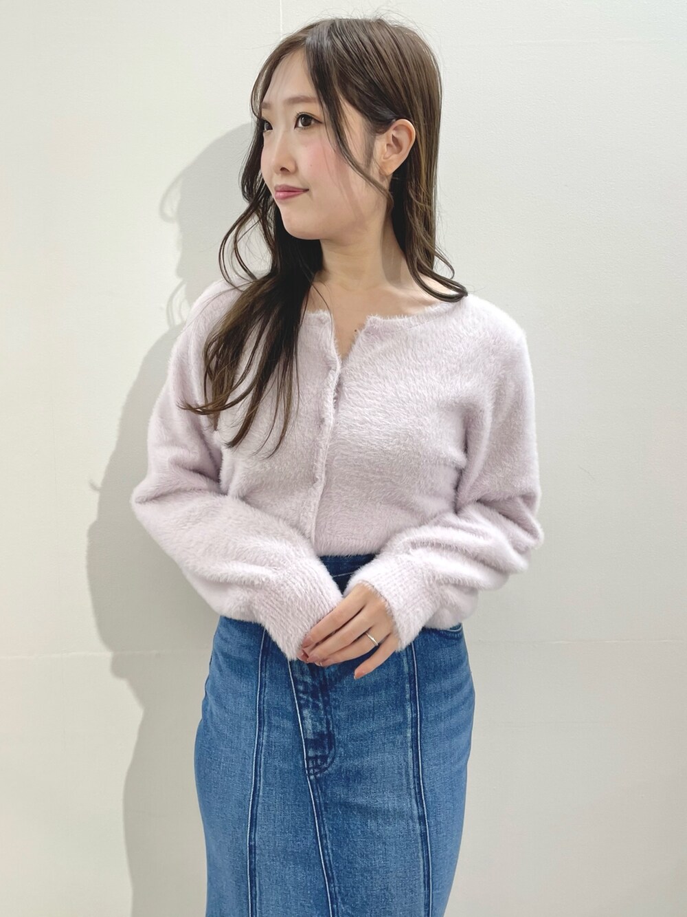 ピンク系のカーディガン/ボレロ、ブルー系のスカート、ホワイト系のブーツを着用したレディースの冬コーディネートの5枚目の写真