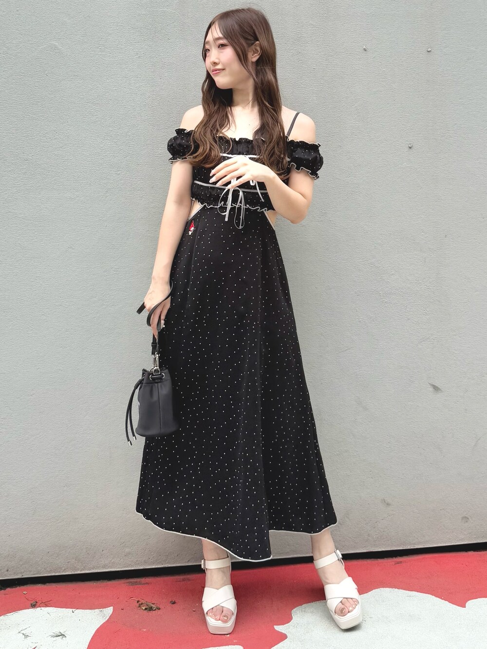 ブラック系のワンピース、ブラック系のショルダーバッグ、ホワイト系のサンダルを着用したレディースの春コーディネートの2枚目の写真