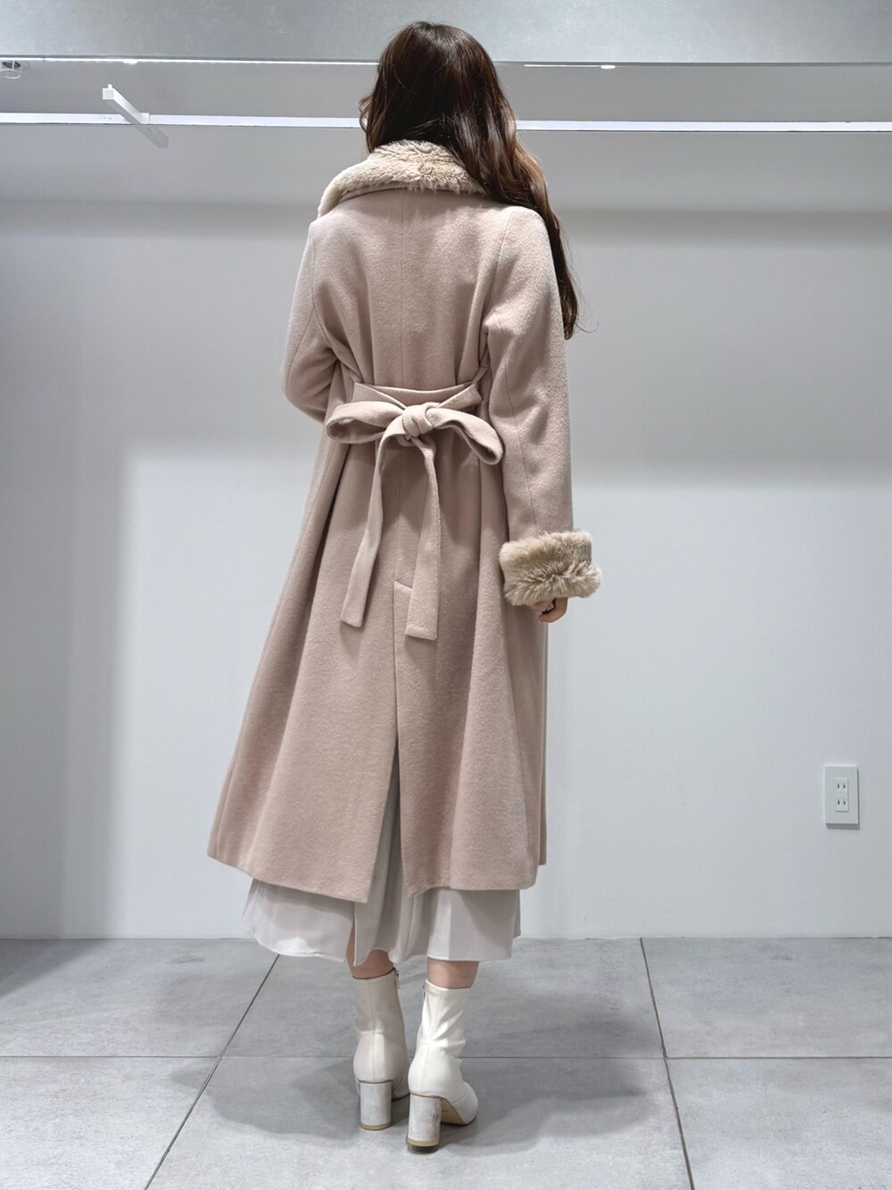 ベージュ系のその他アウター、ホワイト系のワンピース、ホワイト系のブーツを着用したレディースの冬コーディネートの3枚目の写真