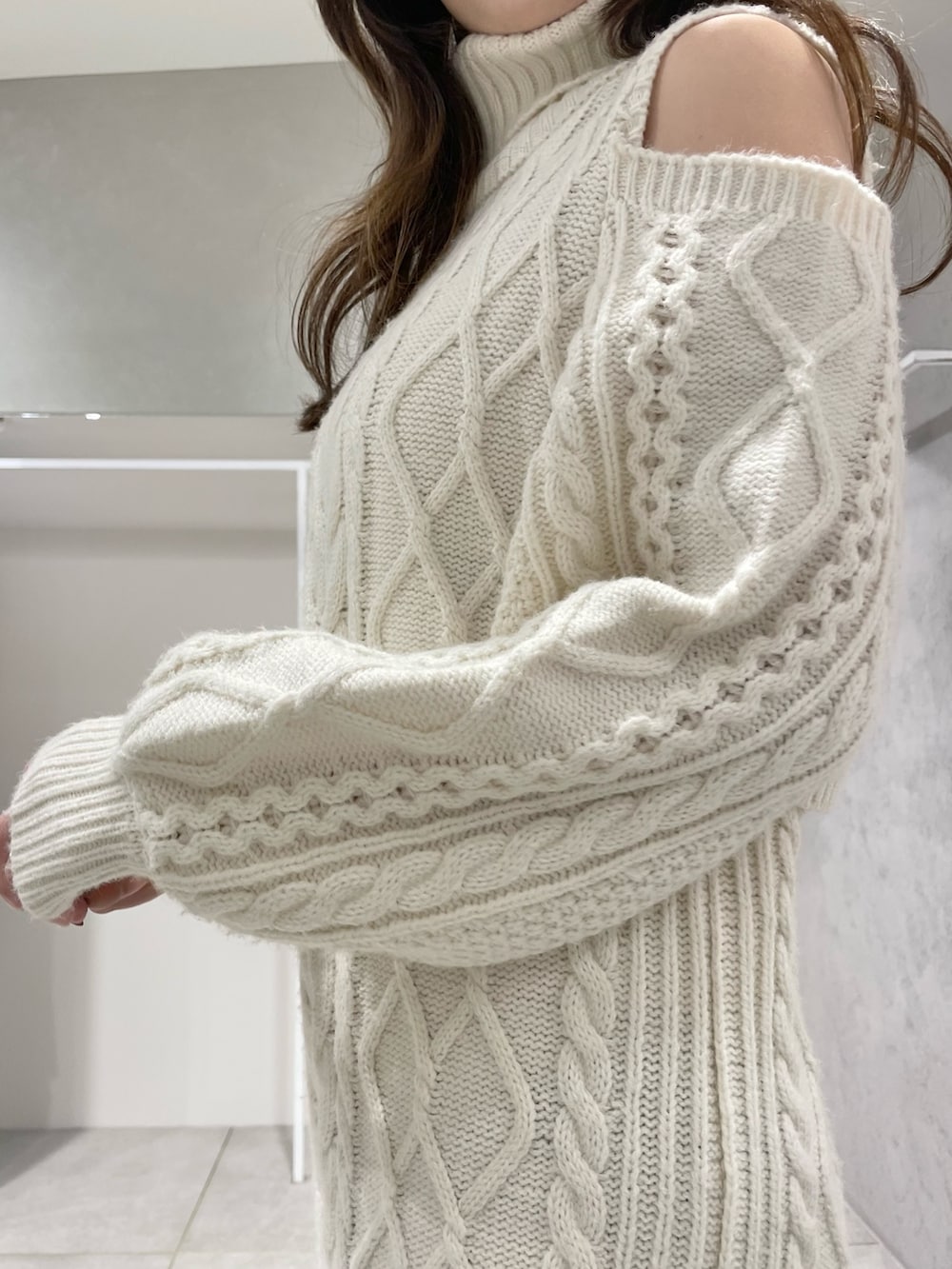 ホワイト系のその他アウター、ホワイト系のワンピース、ブラウン系のブーツを着用したレディースの冬コーディネートの10枚目の写真