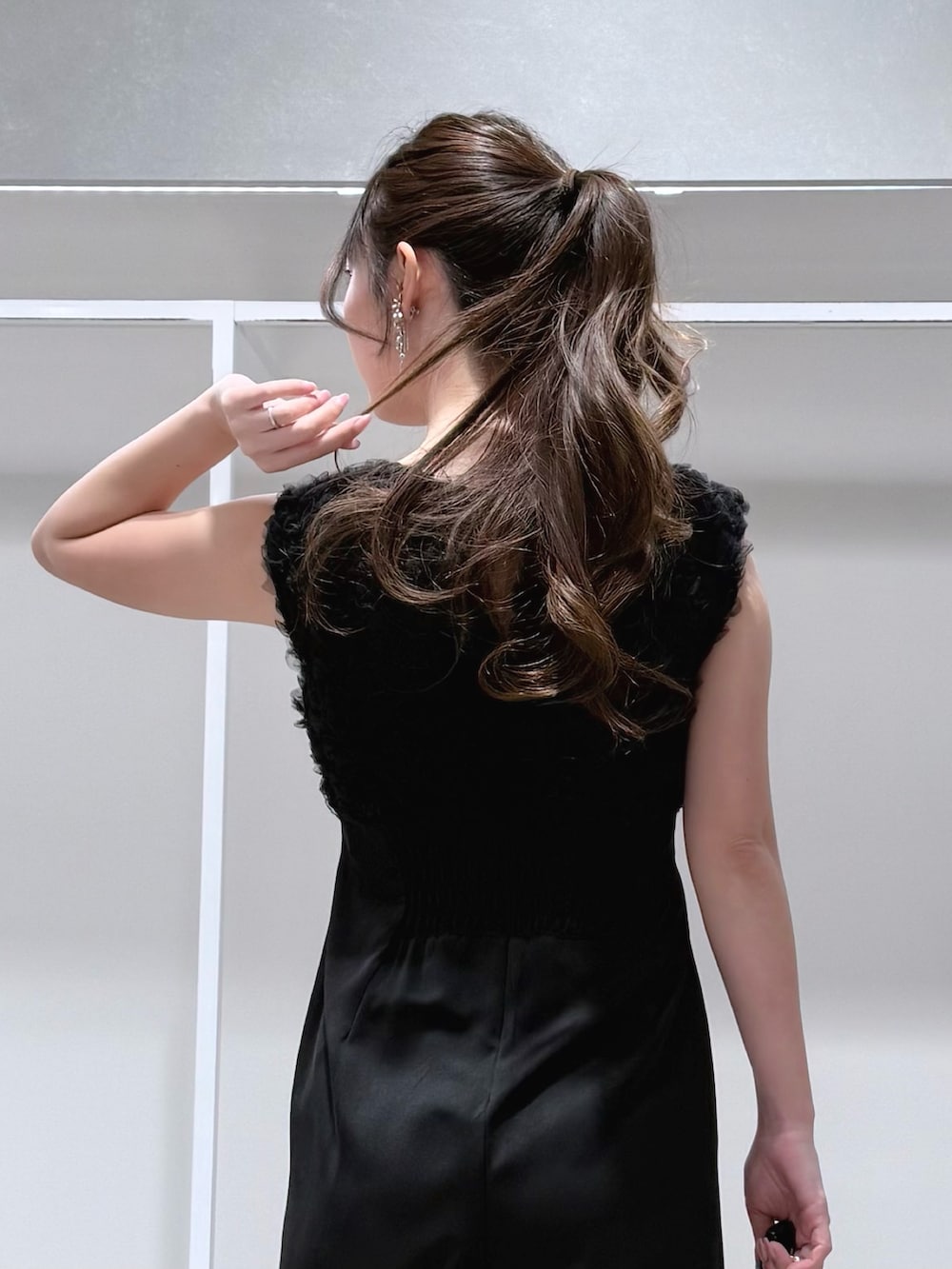 ブラック系のドレス、ゴールド系のショルダーバッグ、シルバー系のパンプスを着用したレディースの冬コーディネートの7枚目の写真