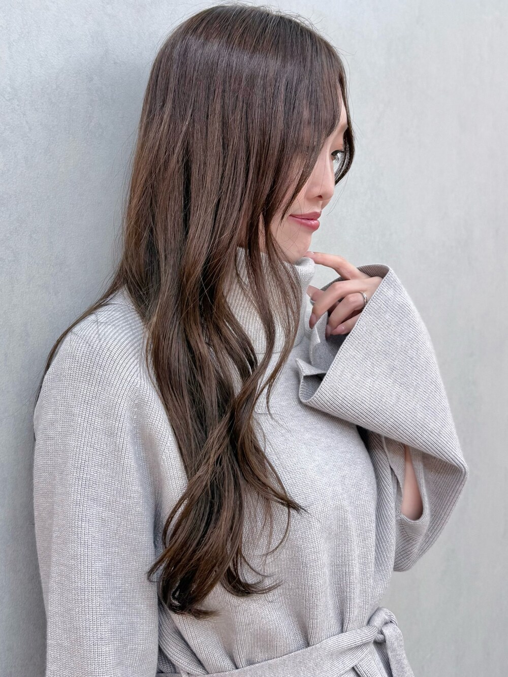 ブラック系のハンドバッグ、グレー系のニット/セーター、ホワイト系のスカートを着用したレディースの夏コーディネートの5枚目の写真