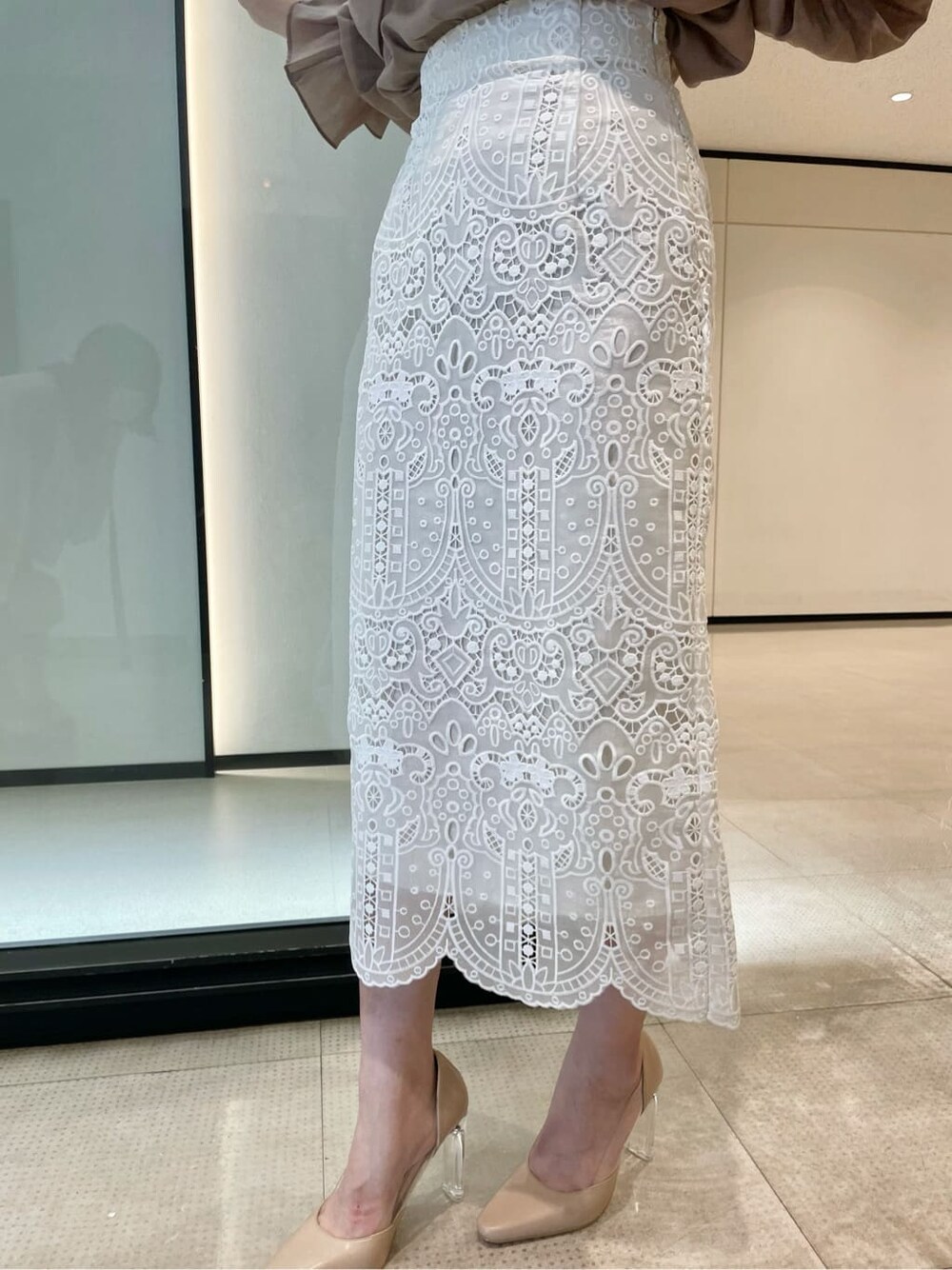 ピンク系のシャツ/ブラウス、ホワイト系のスカート、ベージュ系のパンプスを着用したレディースの夏コーディネートの6枚目の写真