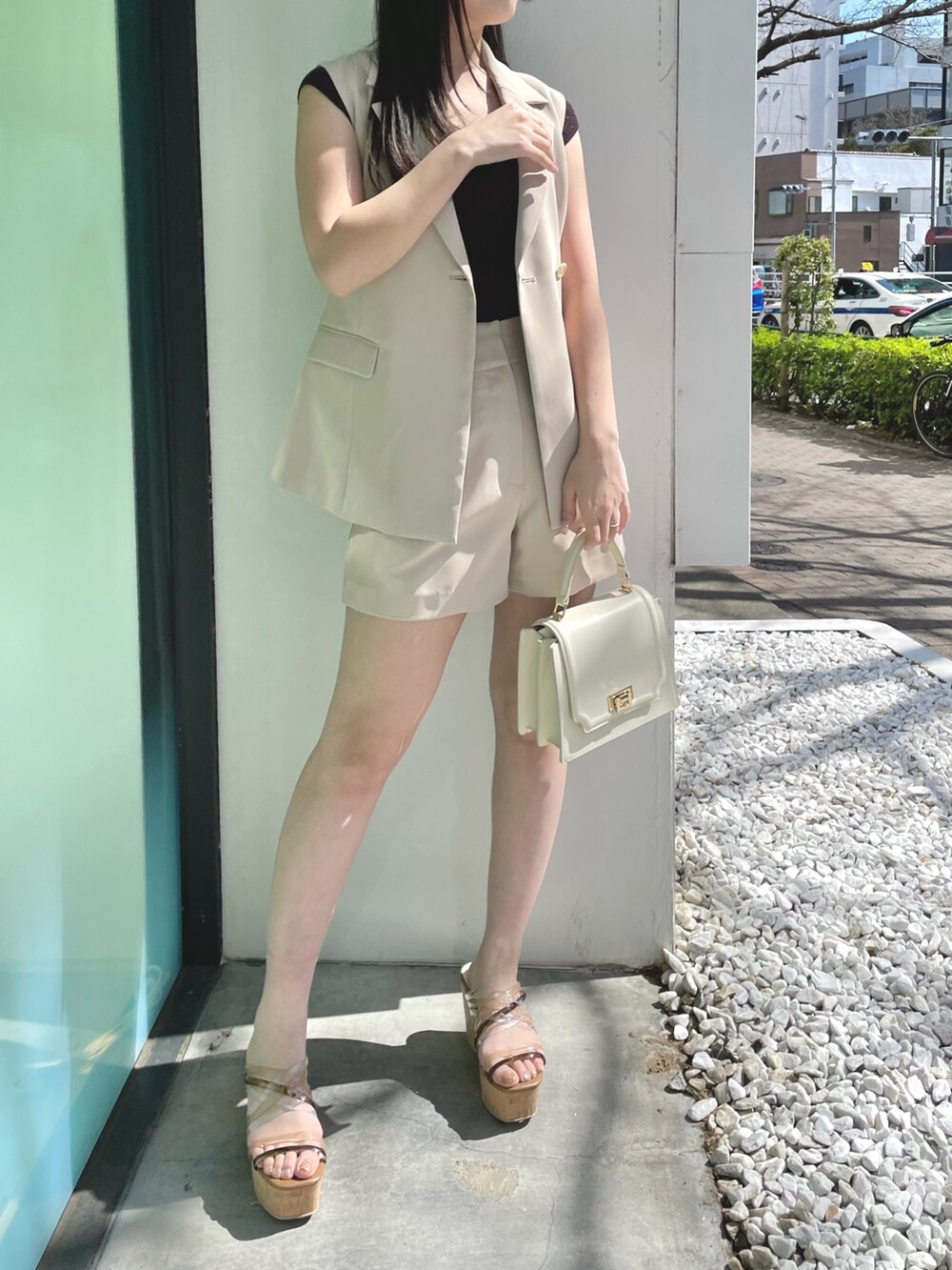 ベージュ系のその他パンツ、ホワイト系のハンドバッグ、ブラウン系のサンダルを着用したレディースの春コーディネートの2枚目の写真