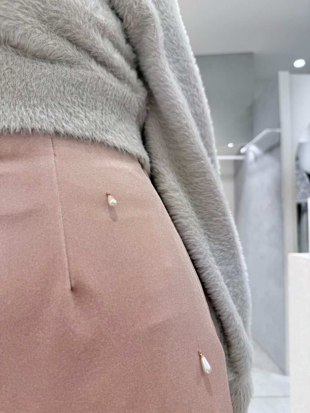 グレー系のカーディガン/ボレロ、ピンク系のスカート、ホワイト系のハンドバッグを着用したレディースの冬コーディネートの6枚目の写真