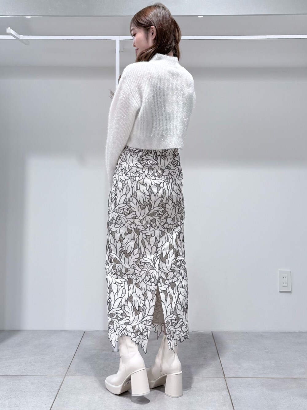 ホワイト系のニット/セーター、ホワイト系のスカート、ホワイト系のブーツを着用したレディースの冬コーディネートの3枚目の写真