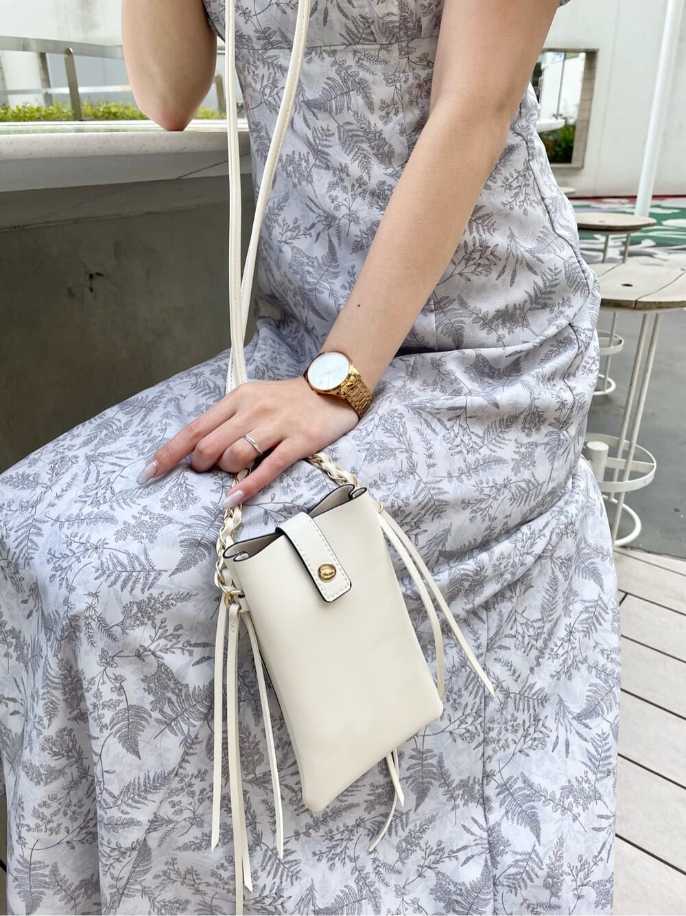 ホワイト系のショルダーバッグ、ピンク系のワンピース、その他のサンダルを着用したレディースの春コーディネートの6枚目の写真