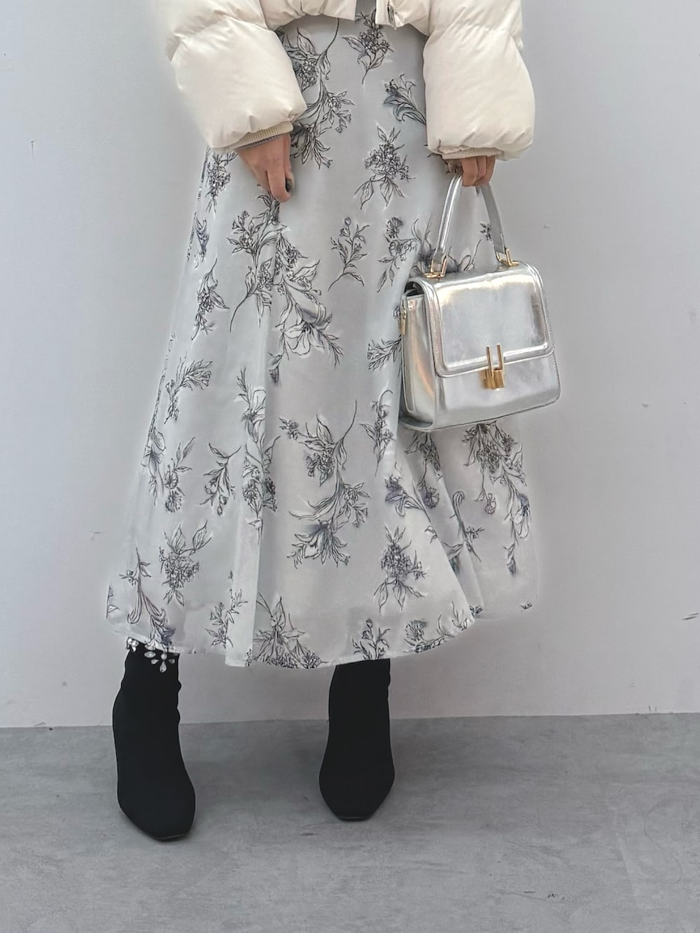 ホワイト系のダウンジャケット/コート、シルバー系のハンドバッグ、ブラック系のブーツを着用したレディースの秋コーディネートの7枚目の写真