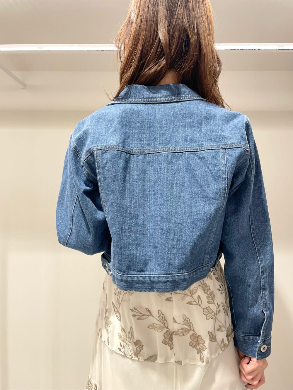 ブルー系のテーラードジャケット、ベージュ系のワンピースを着用したレディースの春コーディネートの4枚目の写真