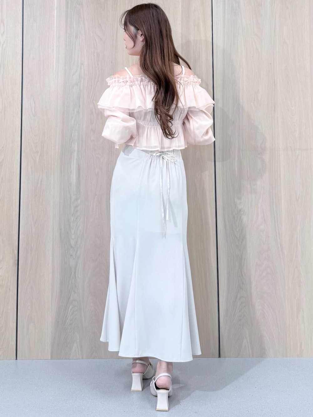 ピンク系のシャツ/ブラウス、ホワイト系のスカート、ホワイト系のパンプスを着用したレディースの春コーディネートの4枚目の写真