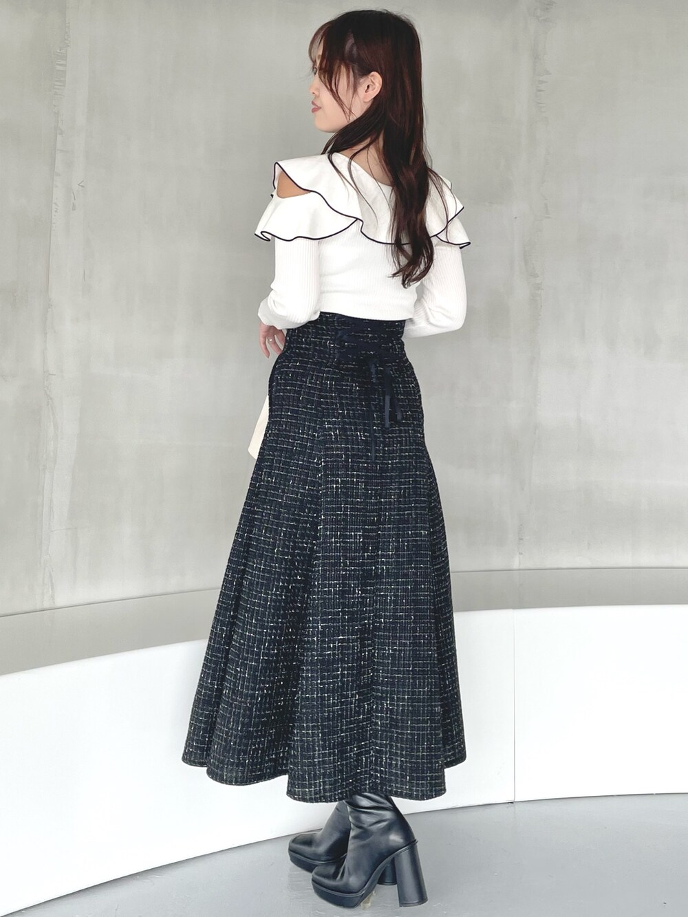 その他のニット/セーター、ブラック系のスカート、ホワイト系のハンドバッグを着用したレディースの秋コーディネートの3枚目の写真