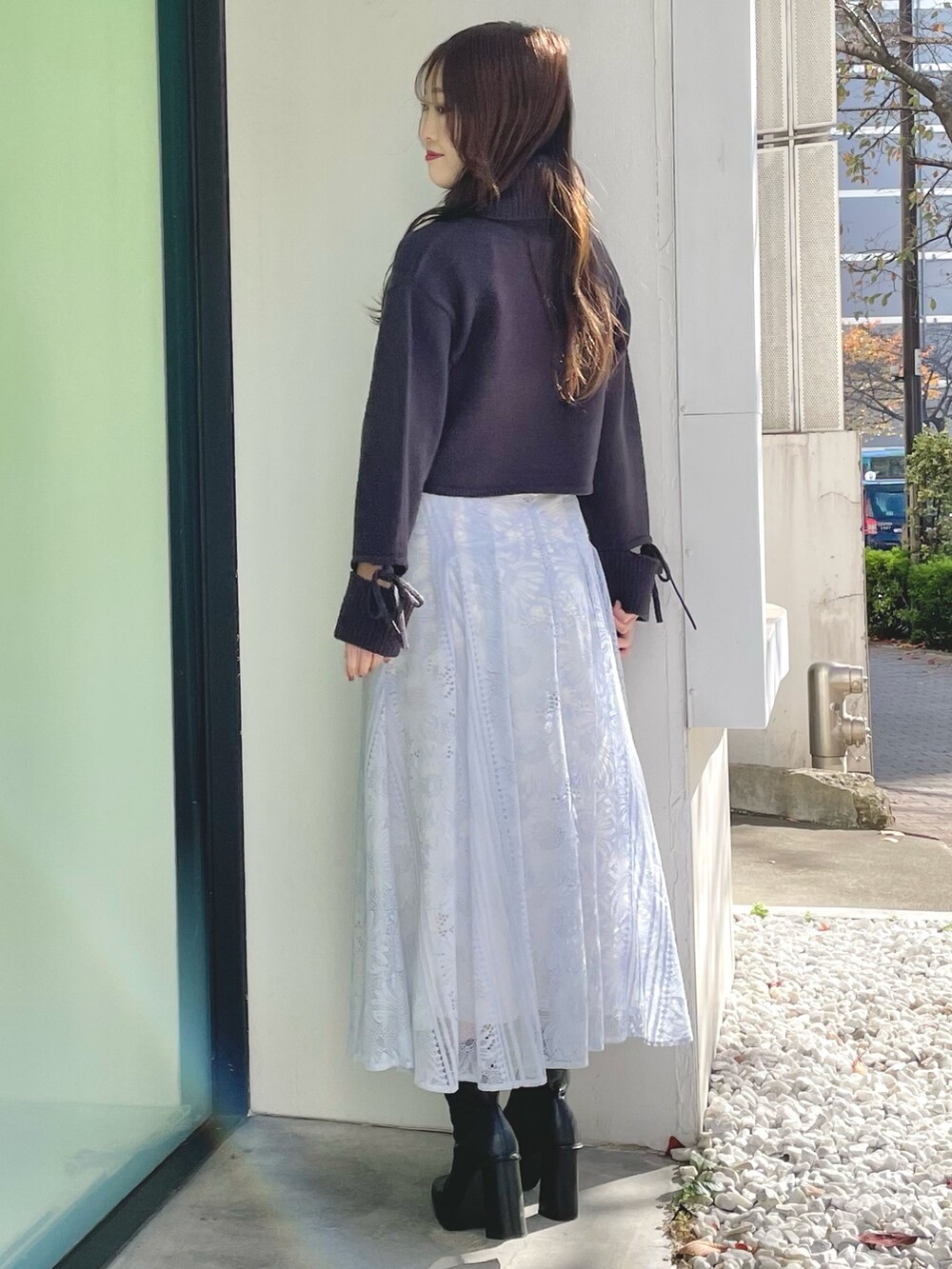 ブルー系のスカート、グレー系のニット/セーター、ブラック系のブーツを着用したレディースの冬コーディネートの5枚目の写真