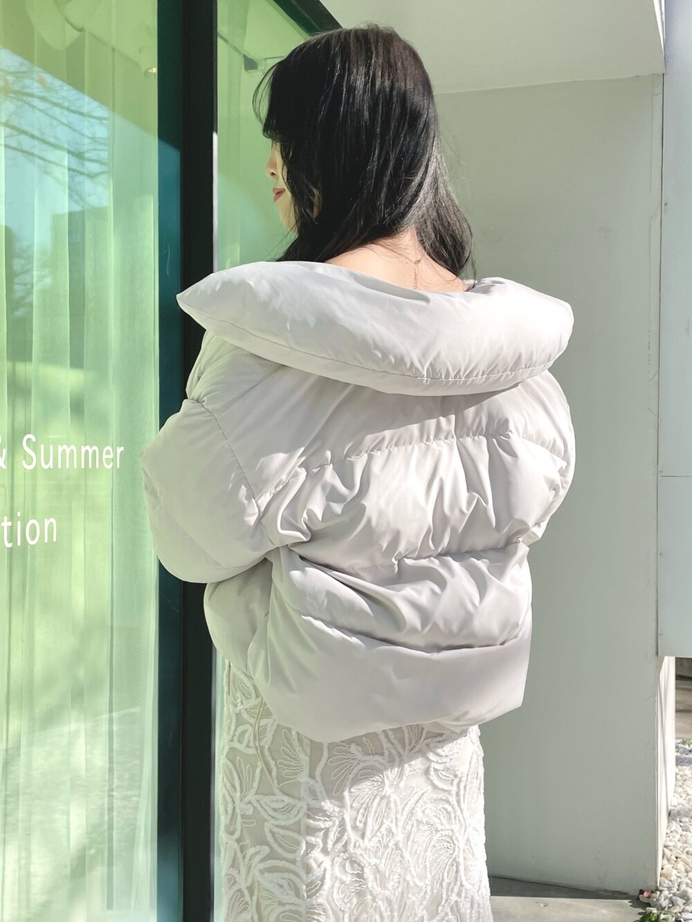 ホワイト系のダウンジャケット/コート、ホワイト系のニット/セーター、ホワイト系のスカートを着用したレディースの冬コーディネートの4枚目の写真