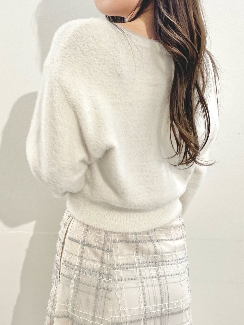 ホワイト系のその他アウター、ホワイト系のスカート、ホワイト系のブーツを着用したレディースの冬コーディネートの7枚目の写真