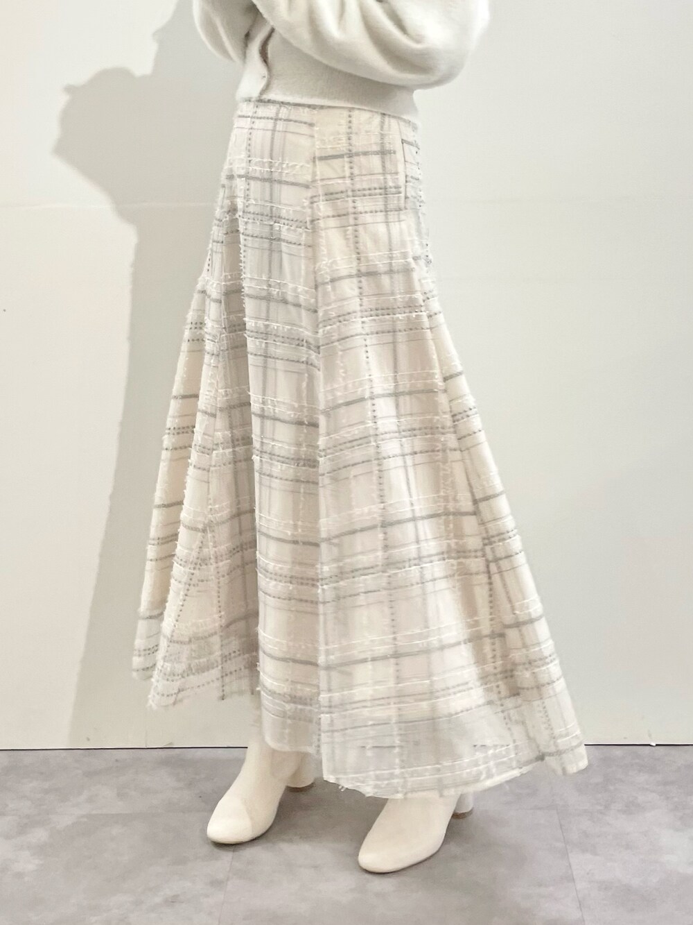 ホワイト系のその他アウター、ホワイト系のスカート、ホワイト系のブーツを着用したレディースの冬コーディネートの8枚目の写真