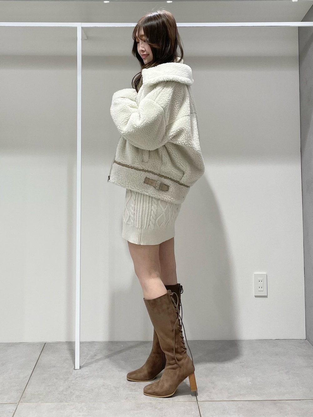 ホワイト系のその他アウター、ホワイト系のワンピース、ブラウン系のブーツを着用したレディースの冬コーディネートの2枚目の写真
